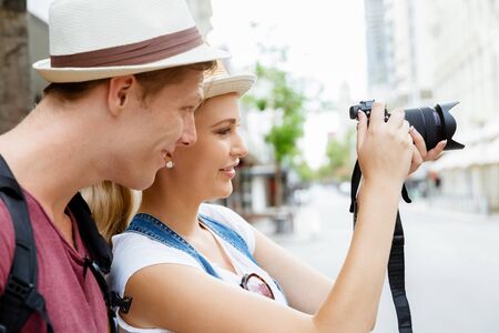 Happy young couple as tourists with a camera