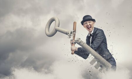 Young emotional woman in suit and hat with baseball batの写真素材