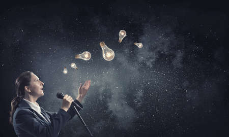 Woman reporter with microphone gesturing with handの写真素材