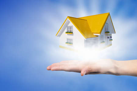 Human hands holding model of dream houseの写真素材
