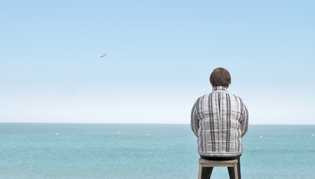 Middle aged stout woman sitting with backの写真素材