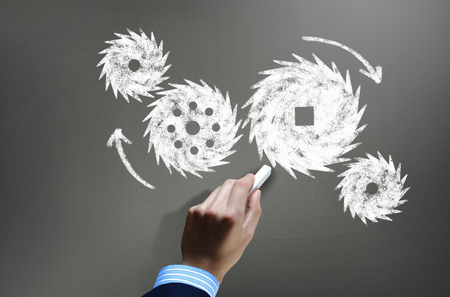 Businessman hand drawing with chalk gears mechanism as teamwork conceptの写真素材