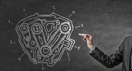 Close up of hand drawing gears mechanism with chalkの写真素材