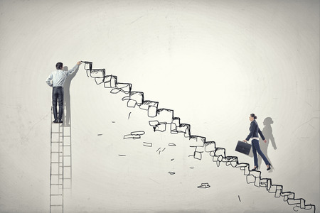 Businesswoman climbing up staircase as symbol of career riseの写真素材