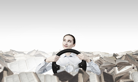 Young smiling pretty woman driving steering wheelの写真素材