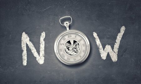 Conceptual image with word now and pocket watch instead of letterの写真素材