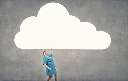 Stout woman of middle age with blank white cloud bannerの写真素材