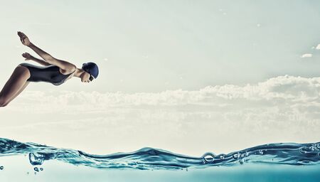Young woman competition swimmer in starting poseの写真素材