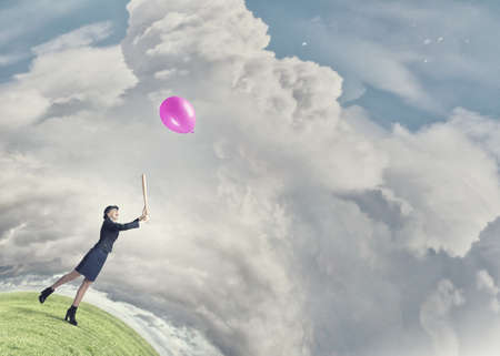 Young pretty woman in suit and hat with baseball batの写真素材