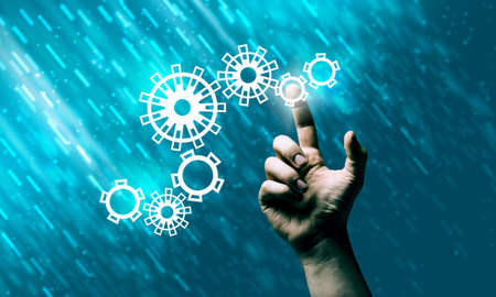 Close up human hand pointing with finger at gears mechanismの写真素材