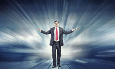 Confident businessman with hands spread apart on digital backgroundの写真素材