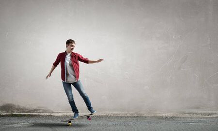 Handsome teenager cool acive boy riding skateboardの写真素材