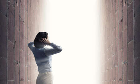 Young frustrated woman standing with back covering ears with arms