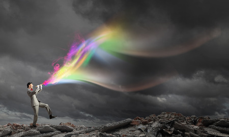 Young businessman in black hat playing fluteの写真素材