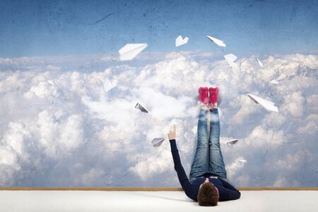 Young woman lying on floor with legs raised upの写真素材