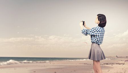 Young beautiful woman taking photo with retro cameraの写真素材