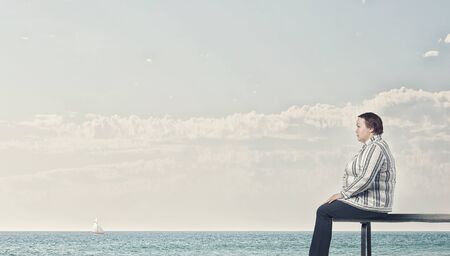 Middle aged stout woman sitting on benchの写真素材