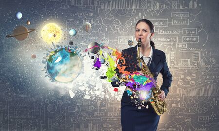 Young woman playing saxophone and colorful splashes coming out. の写真素材