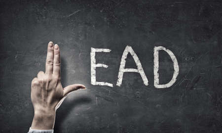 Word lead written on wall and fingers instead of letter Lの写真素材