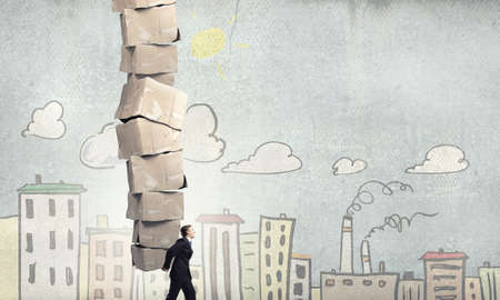 Businessman carrying big stack of carton boxesの写真素材