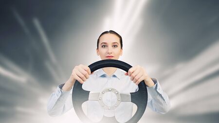 Young smiling pretty woman driving steering wheel