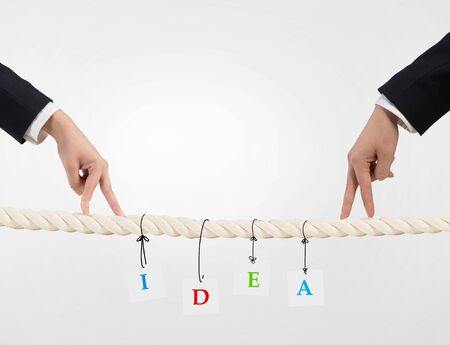 Close up of businessman hands walking with fingers on rope as partnership conceptの写真素材