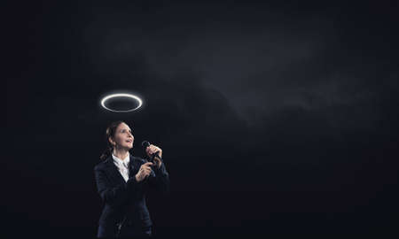 Saint woman reporter with microphone gesturing with handの写真素材