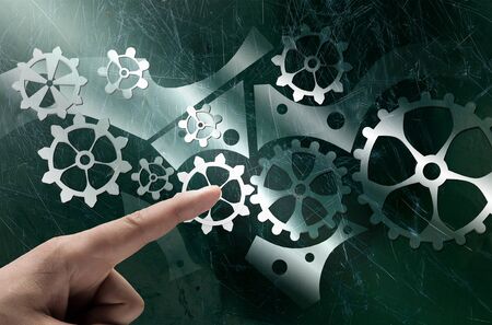 Close up human hand pointing with finger at gears mechanismの写真素材