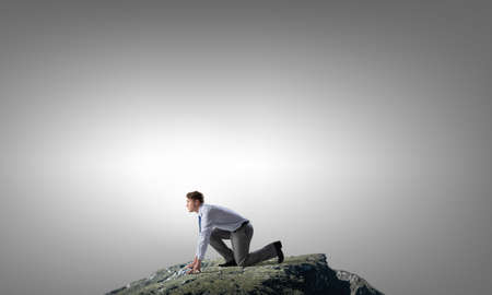 Young determined businessman in starting position ready to competeの写真素材