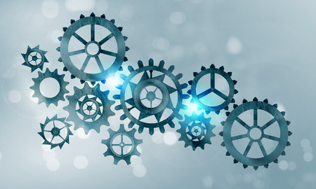 Mechanism of metal gears and cogwheels on blue backgroundの写真素材