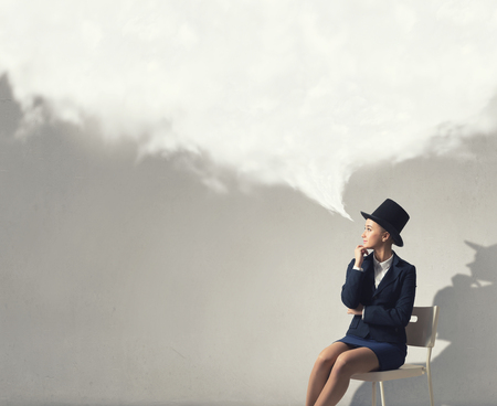Pretty girl wearing retro hat siting on chairの写真素材