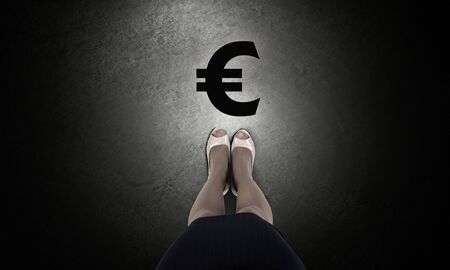 Top view of businesswoman feet and euro sign on floorの写真素材