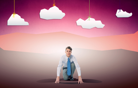 Young determined businessman in starting position ready to competeの写真素材