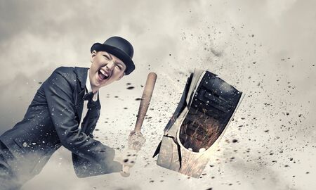 Young crazy woman damaging computer processor with baseball batの写真素材