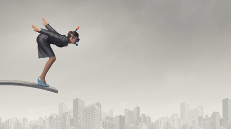 Young businesswoman in suit and diving mask jumping in waterの写真素材