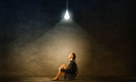 Bored young businesswoman sitting alone on floorの写真素材