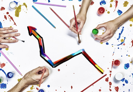 Top view of people hand drawing business growth concept with paints