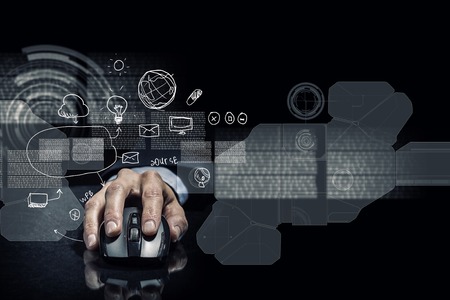 Hand of businessman in suit on dark digital background using wireless computer mouse