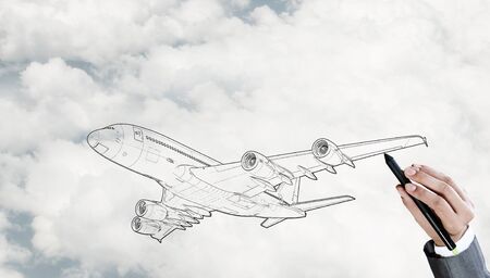 Person drawing airplane model on sky backgroundの写真素材
