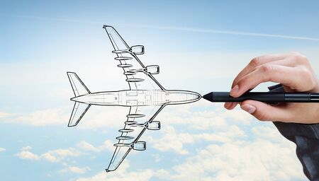 Person drawing airplane model on sky backgroundの写真素材