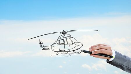 Hand drawing with stylus helicopter model on sky backgroundの写真素材