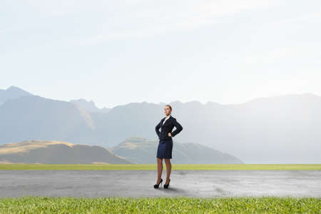 Young confident businesswoman with hands on waistの写真素材