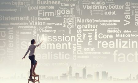 Businesswoman standing on chair and reaching leadership conceptsの写真素材