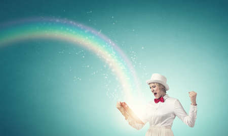 Young emotional woman in white cylinder with book in hand