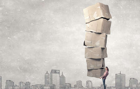 Young girl in casual carrying stack of carton boxesの写真素材