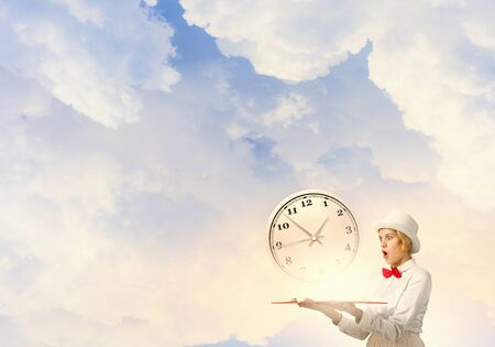 Young woman in white cylinder and red bowtie with book in handsの写真素材