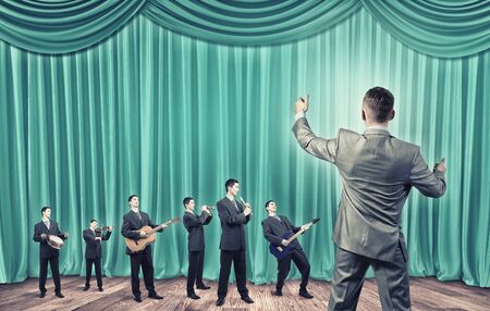 Man orchestra in suit playing different music instrumentsの写真素材