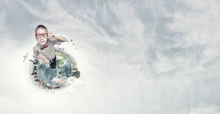Cute schoolboy in red glasses on Earth planet. Elements of this image are furnished by NASAの写真素材