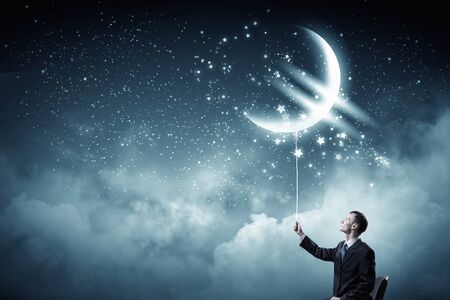 Businessman catching glowing euro currency symbol with ropeの写真素材