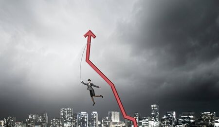 Businesswoman pulling arrow with rope and making it raise upの写真素材